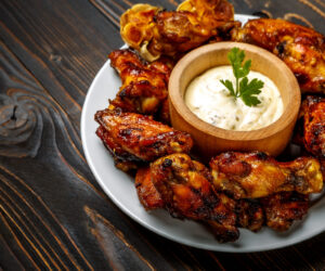 roasted chicken wings with herbs on wooden table