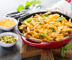 Cheesy pasta bake in a pan with ground beef and herbs