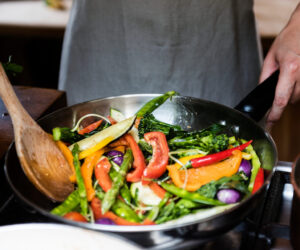 Japanese woman cooking stir fried vegetables