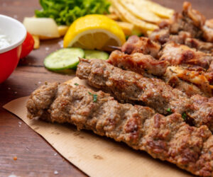 Kebab, traditional turkish, greek meat food on wooden table, tzatziki sauce and potatoes