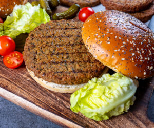 Making tasty vegetarian hamburgers from plant based grilled burgers, fresh bakes buns and organic vegetables close up