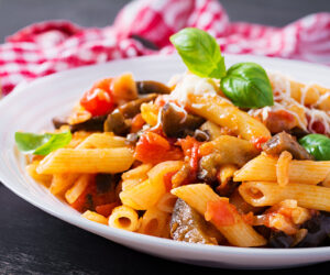 Pasta penne with eggplant. Pasta alla norma - traditional Italian food with eggplant, tomato, ricotta cheese and basil.