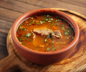 Georgian national kharcho soup with beef and rice on the wooden background